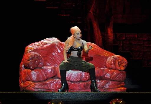Lady Gaga sits on a couch made to resemble meat at Soccer City in Johannesburg. The chair is a reference to her infamous meat dress.