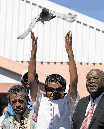 Worcester bomb blast victim Olga Macingwane releases a pigeon to commemorate victims of a racist attack on Christmas Eve 15 years ago. She is flanked by Worcester mayor Basil Kivedo, left, and Professor Jonathan Jansen Picture: ESA ALEXANDER