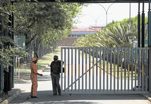 A prisoner speaks to a correctional services officer at the main gate of the violence-racked Groenpunt prison.