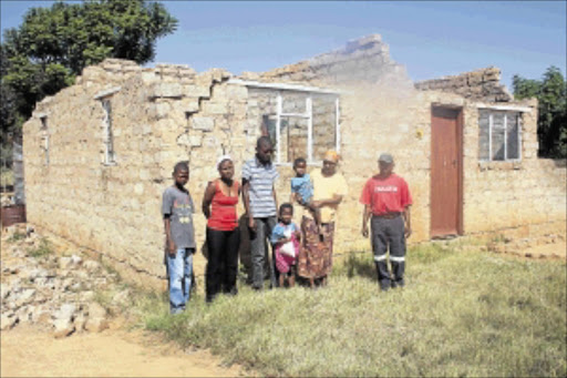 CRACKED: The Mphiwe family of Lefiswane in front of their house, which was destroyed by a freak storm last November. PHOTO: ALFRED MOSELAKGOMO