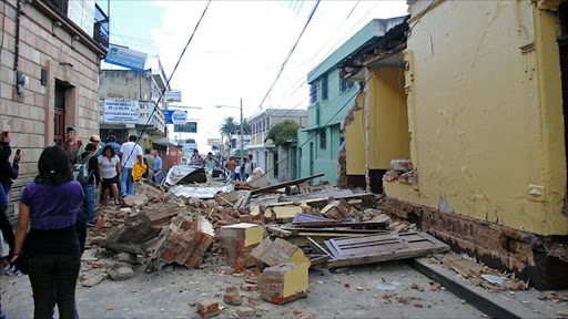 Locals stare at damages in a house in San Marcos, 240 km of Guatemala City, after the city was hit by an earthquake. AFP