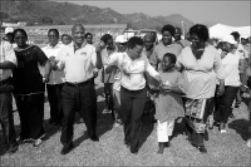 SAFETY ISSUE: MEC Jackson Mthembu and singer Rebecca Malope hold hands with residents at a prayer meeting to seek God's help in reducing road fatalities. Pic. Alfred Moselakgomo. 06/08/08. © Sowetan.