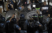 Riot police spry tear gass to Quilmes supporters during the Argentine first division football match against River Plate at Quilmes stadium in Buenos Aires, Argentina, on December 14, 2014. Another riot broke out at a football game in Argentina on 2 March 2015 led to over a dozen police officers being injured and two arrests.