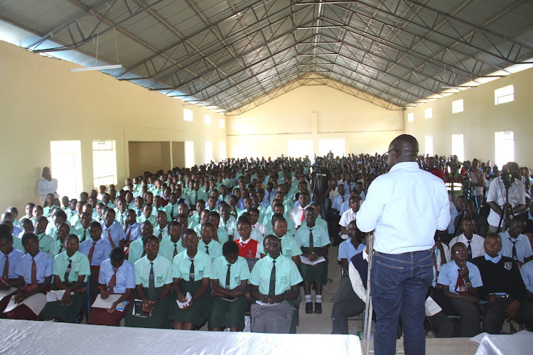 Khwisero MP Christopher Aseka addressing nebeficiaries of the constituency NG-CDF bursaries and scholarships at Mwihila high school on Friday