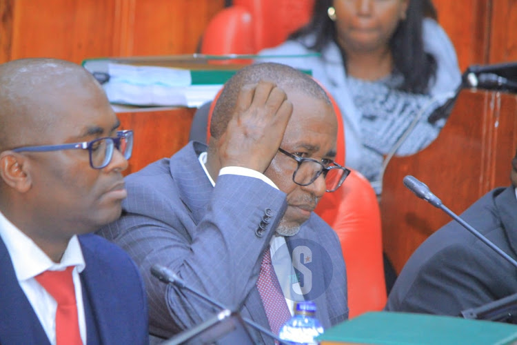 Agriculture Cabinet Secretary Mithika Linturi touches his head as he follows pre-trial impeachment proceedings by the National Assembly select committee at County Hall on May 7, 2024.