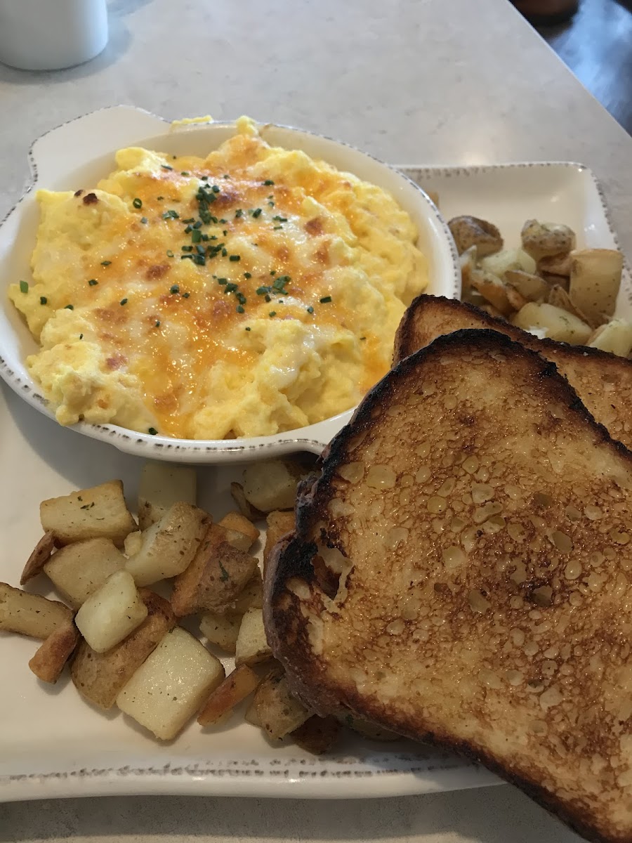 WISCONSIN SCRAMBLE - Eggs scrambled with Swiss, Jack, Cheddar and cream cheese, topped with fresh herbs. Served with your choice of side and an English muffin