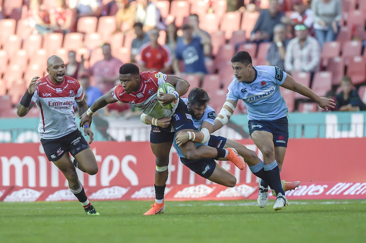 The Emirates Lions' Aphiwe Dyantyi (with ball in hand) and the Waratah's Adam Ashley-Cooper (tackler) in action during the Super Rugby match at the Emirates Airline Park in Johannesburg on May 11 2019.