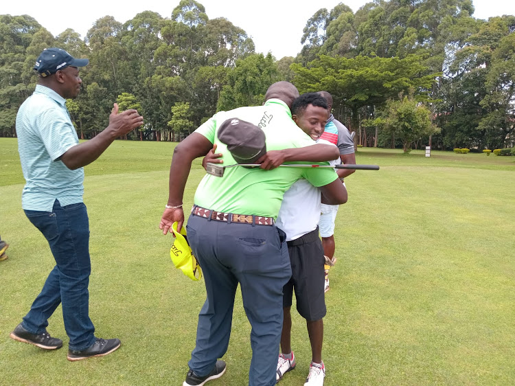 Kiambu golfer Elvis Muigua hugs Kenya Golf Union chairman Philip Ochola