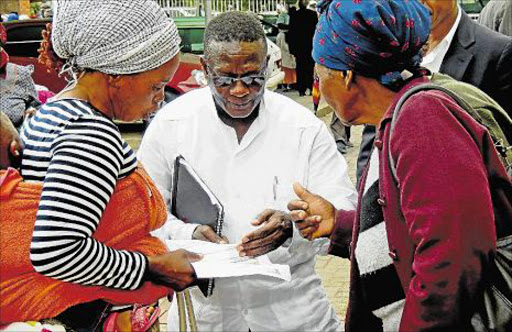 HELPING HAND: Deputy Mineral Resources Minister Godfrey Oliphant speaks with to wives of ex-miners in Ngcobo yesterday, where he said there was around R1.5-billion lying unclaimed in government coffers in the form of unclaimed and that the state was trying to trace about 1400 beneficiaries on its database