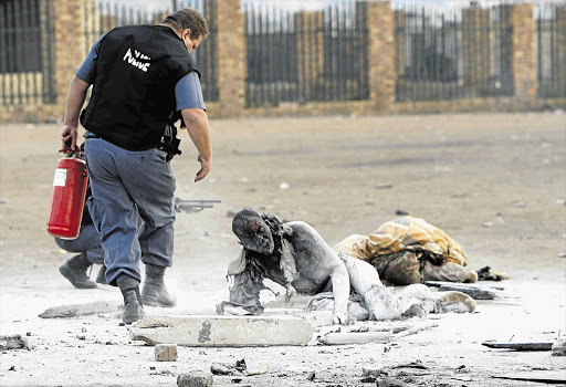 Nhamuave after police doused the flames consuming his body. Sixty-two people died during the wave of xenophobic attacks in 2008, an orgy of violence directed at foreigners. File photo.