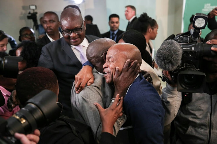 Family members, Reverend Joseph Maboe (Left) hugs Andrew Peterson in celebration, 19 March 2018, in Parktown, Johannesburg after Former Deputy Chief Justice Dikgang Moseneke ordered that the government pay R1.2 million to effected families.