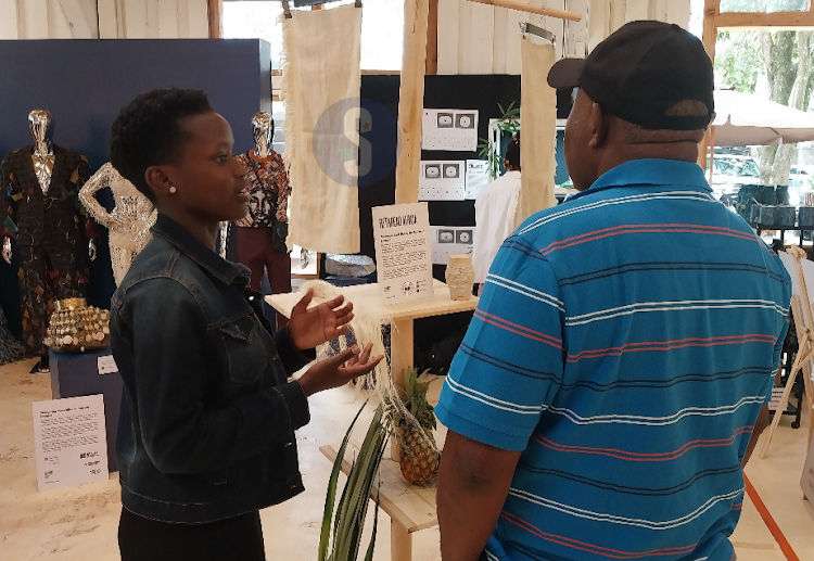 Rethread Africa´s Noreen Mwancha, explaining to an attendee on how they use pineapple leaves to make fabrics at the Nairobi Design Week /