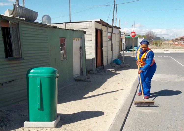 Zingiswa Tshwela sweeps the informal settlement. Since 2009, she has lived in a shack without access to a toilet. Some in Bholobholo have lived this way for even longer.