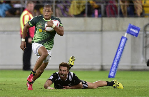 South Africa's Cheslin Kolbe (L) runs out of a tackle by New Zealand's Joe Webber during the cup final on the second day of the Wellington Sevens rugby Union tournament at Westpac Stadium in Wellington on January 31, 2016.