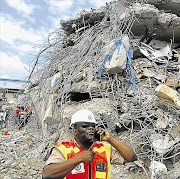 MOUNTAIN OF DESTRUCTION: Nigerian rescue workers search through rubble from the collapsed guesthouse at the Synagogue Church of All Nations in Lagos, Nigeria, on Tuesday