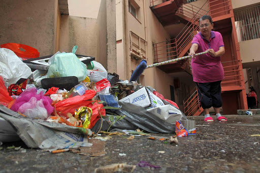 GRIM CONDITIONS: Disgruntled Garcia flats resident Fayroes Kops says the heap of festering garbage just metres from her door step is a serious health hazard and generates flies, cockroaches and maggots Picture: SIBONGILE NGALWA