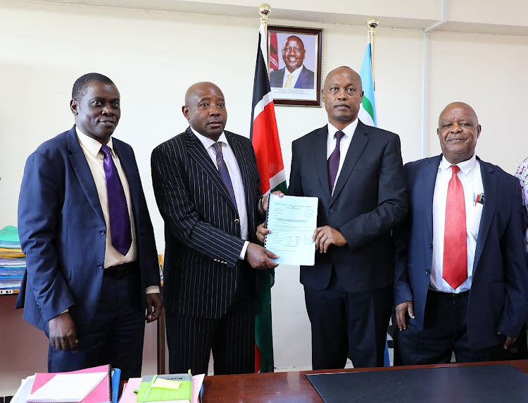 From Left: Dr Danston Barasa( MMUST quality Assurance director, Kakamega deputy governor Ayub Savula, Acting MMUST VC Prof Charles Mutai and task force joint secretary Prof Kubasu Kwashe during handing over of the report on the proposed upgrade of Eregi TTC to MMUST campus in the VC's board room on Tuesday