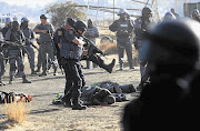 Police check on casualties are opening fire on Marikana strikers. File photo.