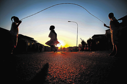Children play in the street at sunset when some say they should be getting ready for bed
