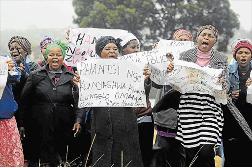 ENOUGH IS ENOUGH: Women from Kuni village near Needs Camp yesterday demonstrated in the rain to demand police intervention in a series of crimes in their community Picture: SIBONGILE NGALWA