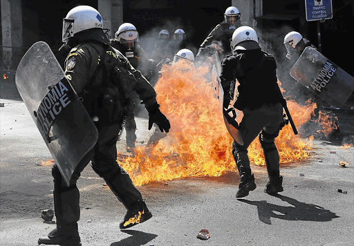 Riot police try to avoid petrol bombs thrown by protesters in Athens' Syntagma Square during a 24-hour strike yesterday. Police fired teargas at youths hurling petrol bombs and stones as thousands took to the streets in Greece's biggest anti-austerity demonstration in months Picture: REUTERS
