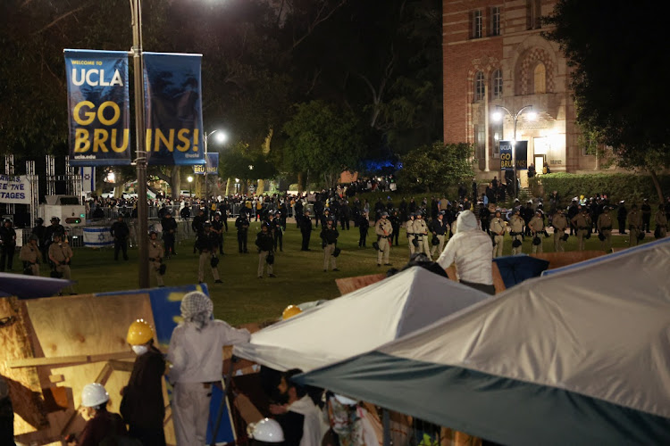 Law enforcement officers stand guard in front of protesters supporting Palestinians in Gaza, at an encampment at the University of California Los Angeles (UCLA), as the conflict between Israel and the Palestinian Islamist group Hamas continues, in Los Angeles, California, US, May 1, 2024.