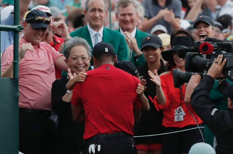 Tiger Woods hugs his son Charlie Axel as his mother Kultida Woods (L), daughter Sam Alexis and girlfriend Erica Herman (R) look on. He rushed to them after he won the 2019 Masters.