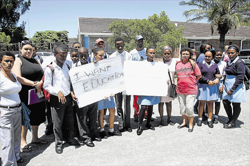 LET US IN: Some of the learners who have not been placed into schools this year are seen here holding up placards at Greenpoint High School Picture: S1BONGILE NGALWA