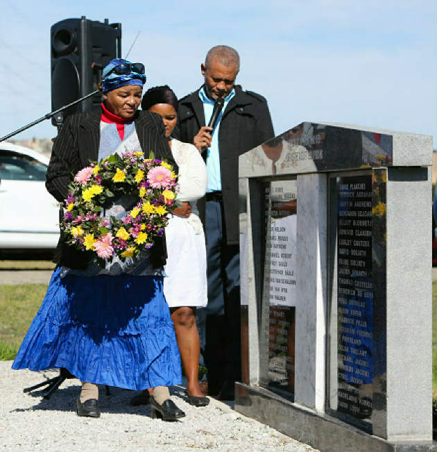 Family members and municipal officials lay wreaths at a commemorative ceremony in the Papenkuil cemetery for the people who died during the 1990 northern areas uprising. Maria de Bruyn lays a wreath for her brother, Thomas Costello, who was killed