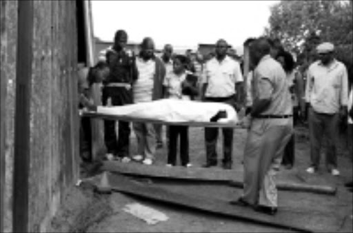 DEAD END: Etwatwa police remove the body of cop killer Mpiliso Ndlovu, who is also accused of killing nine people. Circa 03/ 2009. © Sowetan. Pic. Dan Fuphe.