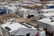 A Syrian refugee woman walks in a makeshift refugee camp in the eastern Lebanese town of Dalhamiyah on May 30, 2014. File photo