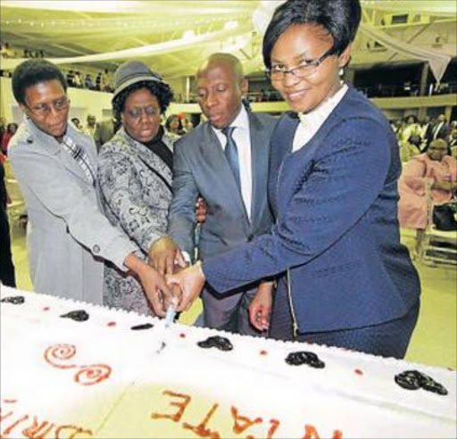 Tshepho Machaea cuts a cake with his wife Tofie.