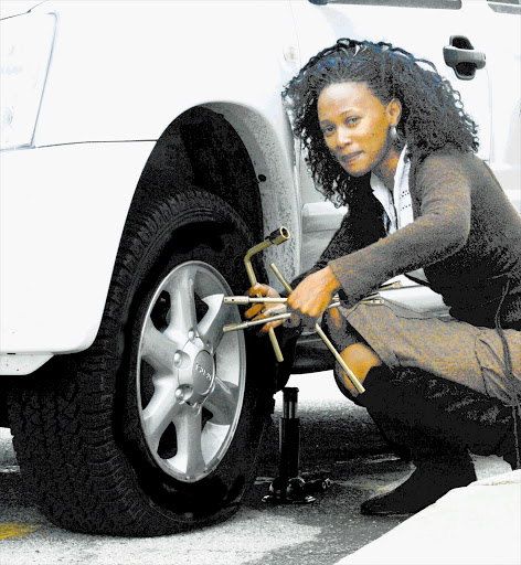Zodidi Somi changes a flat tyre. It is essential to check your tyres regularly Picture: BRIAN WITBOOI