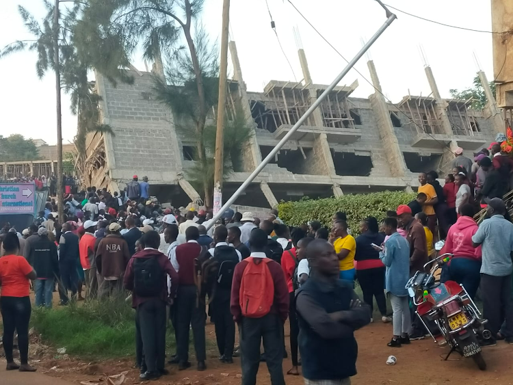 Onlookers mill around the building that collapsed in Murang'a on Monday, June 19, 2023.