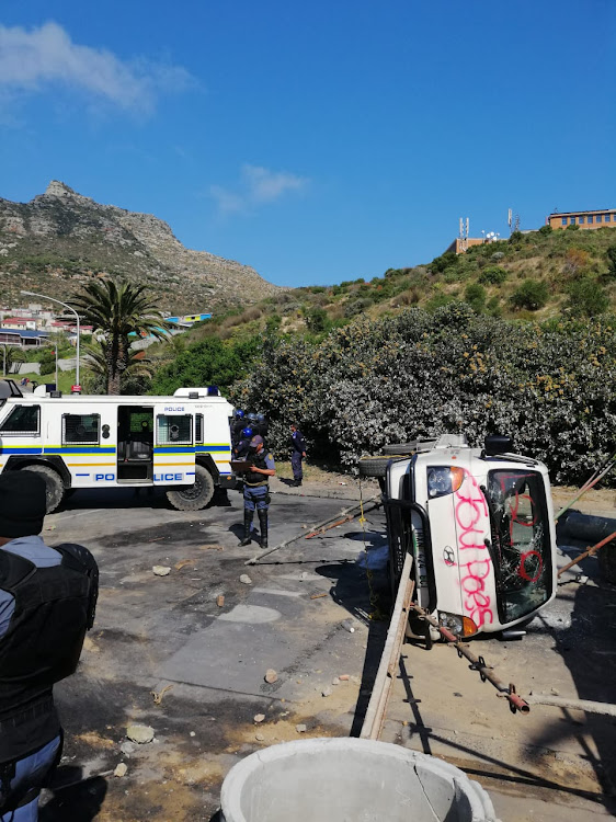 Vehicles were overturned and building materials burned as protesters closed off Harbour Road in Hout Bay on Tuesday.