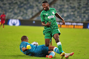 Itumeleng Khune of Warriors FC tackles Victor Letsoalo of Amabutho in the DStv Compact Cup semi-final at Moses Mabhida Stadium in Durban on January 22 2022.