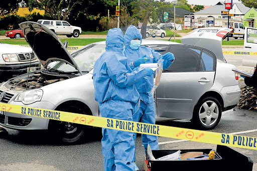 CRUCIAL: Experts examine a car used in a crime in PE Picture: MIKE HOLMES