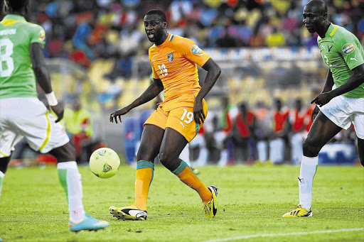 Yaya Toure of Ivory Coast, centre, against Komlan Amewou of Togo during their Africa Cup of Nations match at the Royal Bafokeng Stadium, Phokeng, on Tuesday. The influential player wants to end his country's 21-year cup drought by winning the Afcon Picture: SYDNEY SESHIBEDI