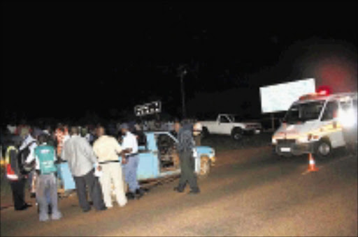 BLOODY AFTERNATH: Police officers investigate the scene where two alleged robbers were shot dead during a shootout with police near the Mvudi Bridge. Cicra 2009. Pic. Chester Makana. © Sowetan.