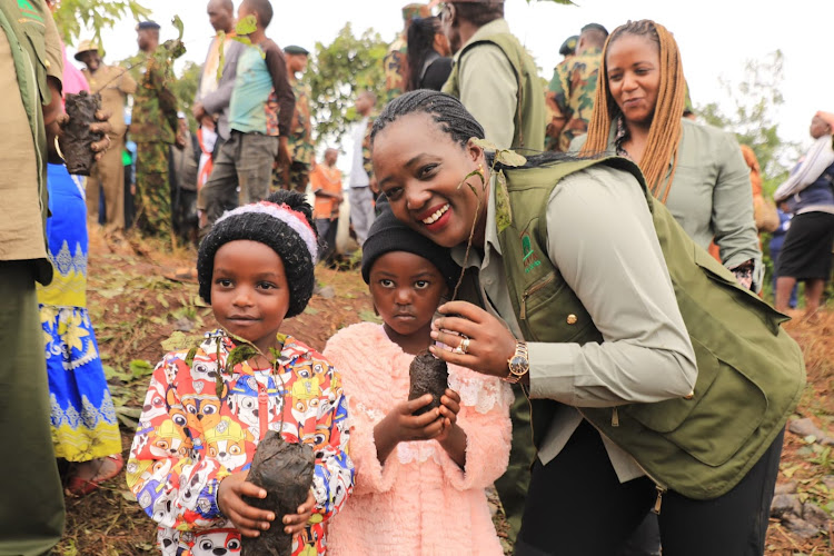 Environment Cabinet Secretary Soipan Tuya poses for a photo with children during the tree planting exercise in Murang'a on May 10, 2024.