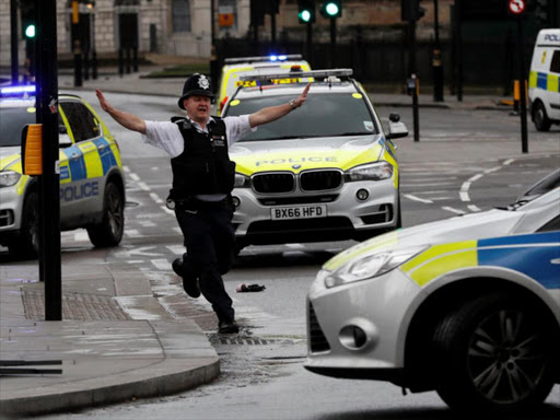 A police officer gestures outside Parliament during an incident on Westminster Bridge in London, Britain March 22, 2017. /REUTERS