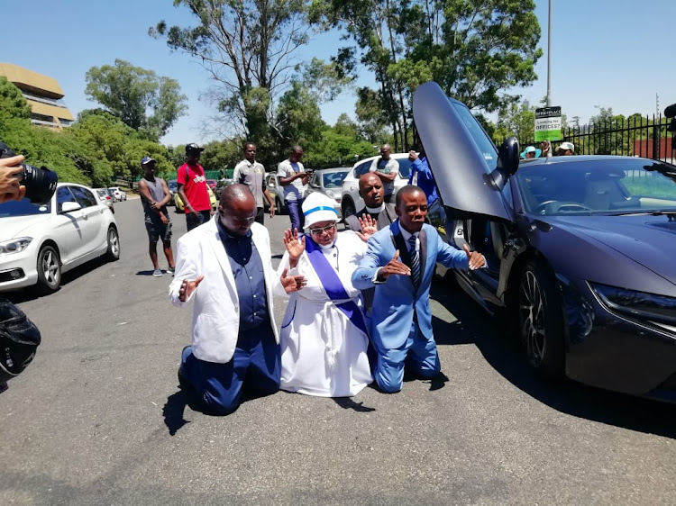 Incredible Happenings Ministries leader Paseka 'Mboro' Motsoeneng prays next to his BMW i8 before he goes to the Sandton police station to lay a charge against pastor Alph Lukau, of Alleluia Ministries on Thursday February 28 2019.