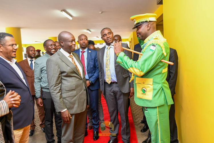 Deputy President Rigathi Gachagua engage with a guard at the UDA headquarters on April 15, 2024.