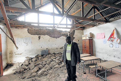 CRESTFALLEN: Nyandeni Junior Secondary School teacher Siyabulela Nqeketho inspects the damaged classroom. The wall collapsed early yesterday morning Picture: LULAMILE FENI