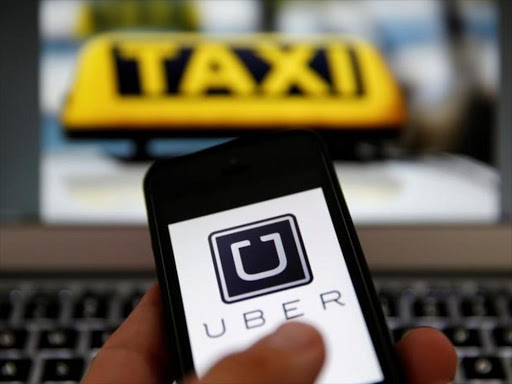 An illustration picture shows the logo of car-sharing service app Uber on a smartphone next to the picture of an official German taxi sign September 15, 2014. /REUTERS