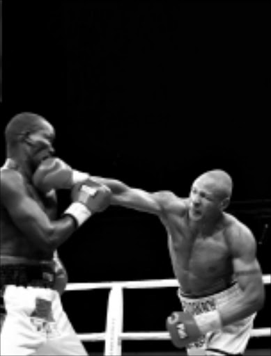 STRAIGHT RIGHT: Isaac Chilembe, right, lands a punch on David 'Bassaja' Kitooke during their WBO Africa light heavyweight title fight at Graceland, Mpumalanga, on Saturday. Pic: ANTONIO MUCHAVE. 14/06/2009. © Sowetan.