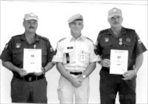 AWARDED: Tony Mundell, left, and Robbie Robertse, right, with UN police commissioner in Sudan Kai Vittrup when the two KwaZulu-Natal police officers were awarded medals of excellence. © Unknown.