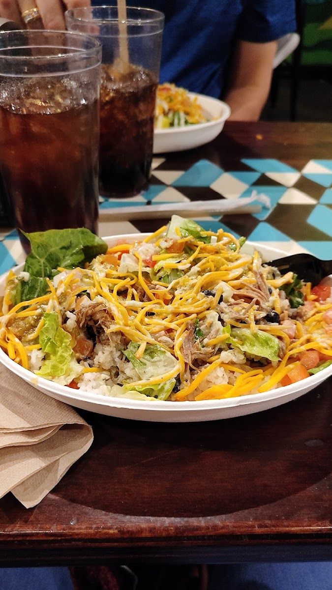 Pork rice bowl with lettuce, tomato, cheddar, tomatillo salsa and avocado ranch.