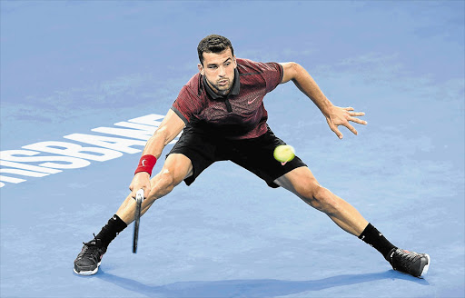 STRUNG OUT: Grigor Dimitrov of Bulgaria returns during his match against Jeremy Chardy of France at the Brisbane International Tennis Tournament in Australia yesterday. The talented Dimitrov is expected to win a Grand Slam this year