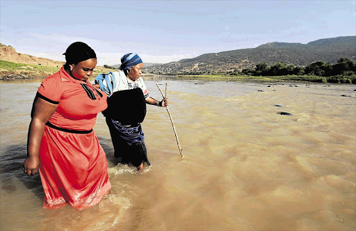 Zenzi Mchunu and Khethiwe Kubheka must wade across the uThukela River to collect their monthly government grants. When the river is swollen it becomes almost impossible for the elderly to cross. It has claimed many victims, they say Picture: TEBOGO LETSIE